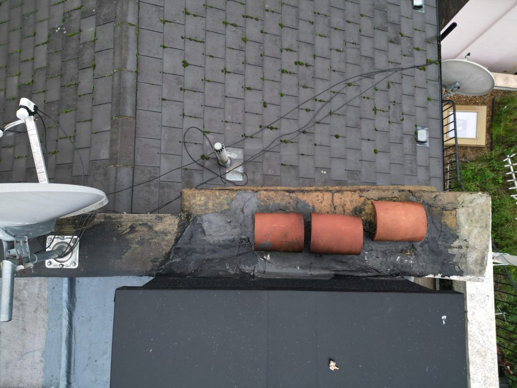Drone image of a patched parapet coping and moss on slates
